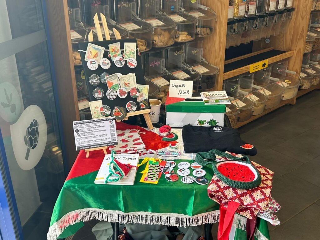 Stand solidaire installé dans un commerce de vrac en Bretagne, avec créations bénévoles et boîte à dons